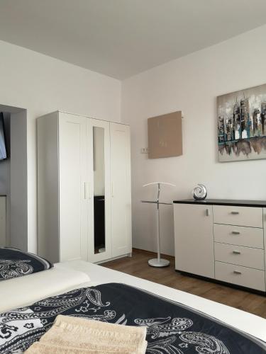 ハーフェルベルクにあるHavelberg Ferien Apartments HCRの白いベッドルーム(ベッド1台、ドレッサー付)