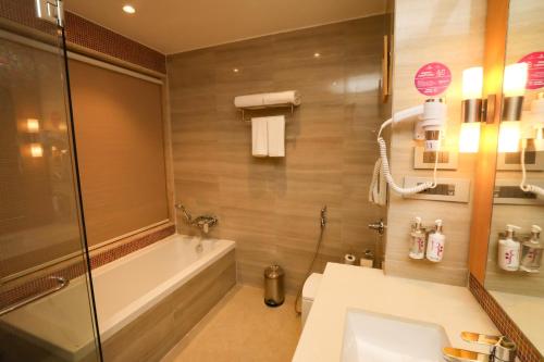 a bathroom with a shower and a sink and a toilet at Regenta Central Udaipur, Court Circle in Udaipur