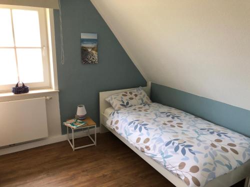 a small bedroom with a bed and a window at Ferienhaus SPO 54 grad in Sankt Peter-Ording