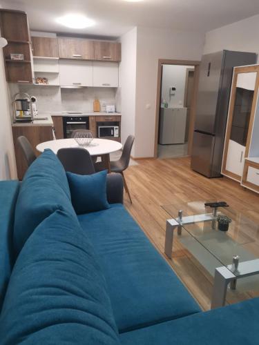 a living room with a blue couch and a kitchen at Brand new apartment with free parking near city center in Sofia