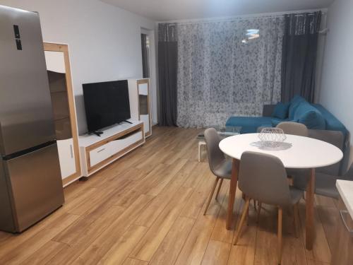 a living room with a table and a tv at Brand new apartment with free parking near city center in Sofia