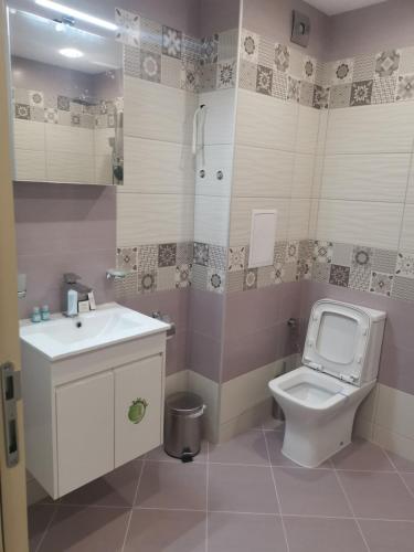 a bathroom with a white toilet and a sink at Brand new apartment with free parking near city center in Sofia