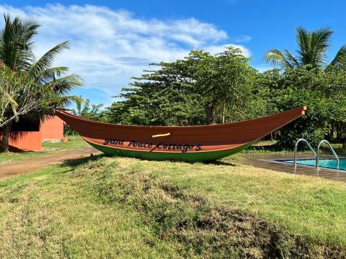 a boat sitting on the grass next to a pool at Yala Peace Cottages in Tissamaharama