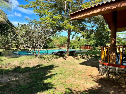a resort with a swimming pool and a yard at Yala Peace Cottages in Tissamaharama