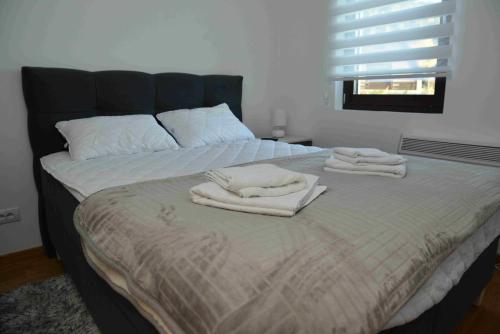 a bed with two towels on top of it at Vila Irina Kopaonik in Kopaonik