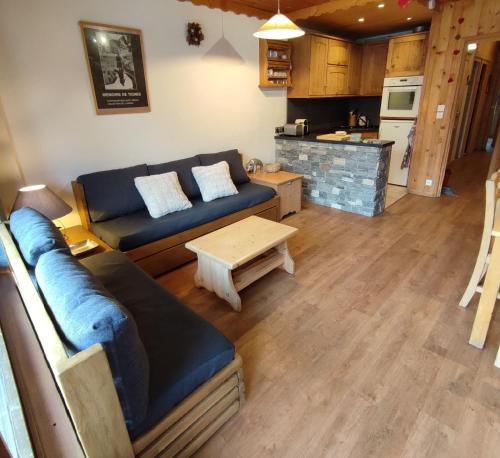 een woonkamer met een bank en een tafel bij Appartement au lac ski aux pieds in Tignes