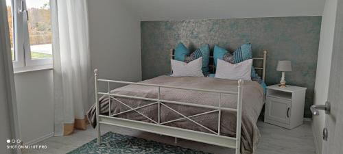 Schlafzimmer mit einem Bett mit blauen und weißen Kissen in der Unterkunft La Casa di Gino in Engelsbrand