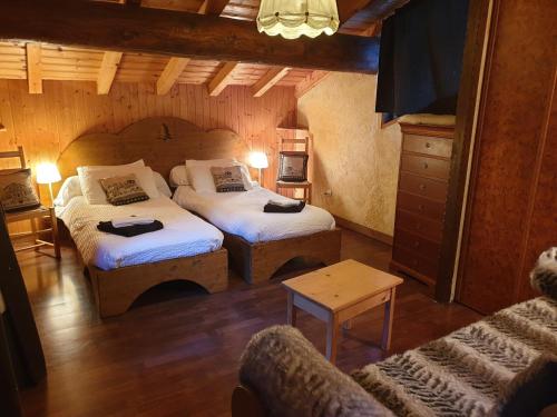 ティーニュにあるCHALET ALISTELLE - 10 à 12 personnes - TIGNES LES BREVIERESのベッド2台とソファが備わる小さな客室です。
