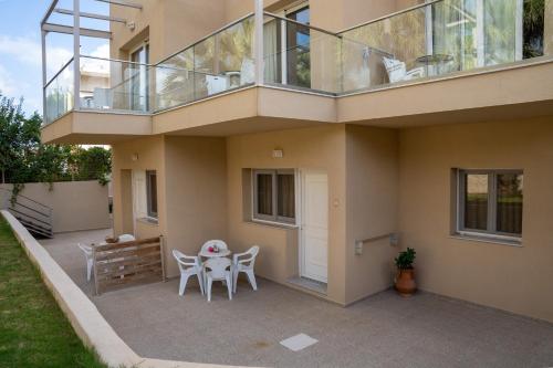 a balcony on a house with a table and chairs at Blue Sky Apartments in Malia