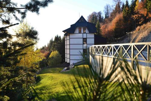 a small white building on a hill with a bridge at Vila Irina Kopaonik in Kopaonik