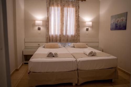 a bedroom with two beds and a window at Blue Sky Apartments in Malia
