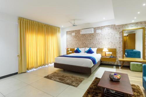 a bedroom with a king sized bed and a living room at Royal Ace Boutique Hotel in Bengaluru
