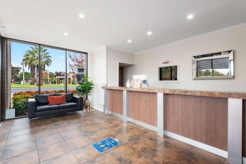 a lobby with a waiting area with a couch and a window at Comfort Inn Deakin Palms in Mildura