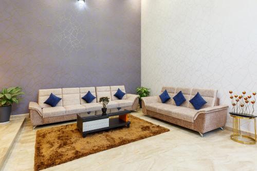 a living room with two couches and a coffee table at Royal Ace Boutique Hotel in Bengaluru