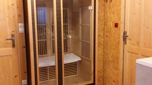 um chuveiro com portas de vidro na casa de banho em MAISON LUPINS 8 PERSONNES em Geishouse