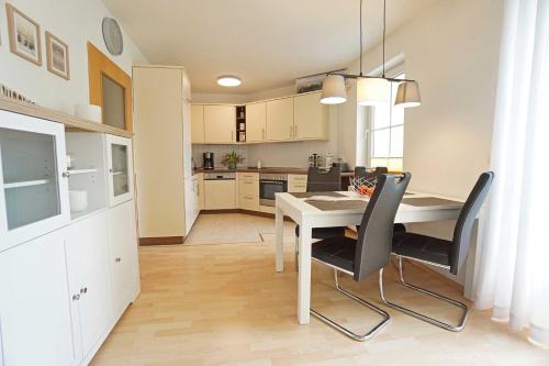 班辛海的住宿－Duenenresidenz Bansin，厨房以及带桌椅的用餐室。