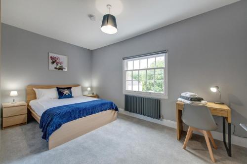 Schlafzimmer mit einem Bett, einem Schreibtisch und einem Fenster in der Unterkunft Bay Tree Apartments in Derby