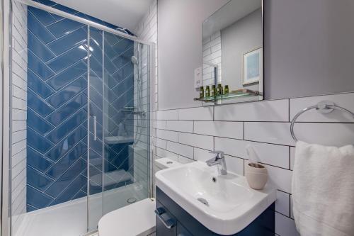 ein Bad mit einer Glasdusche und einem Waschbecken in der Unterkunft Bay Tree Apartments in Derby