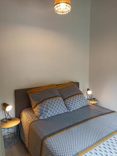 1 dormitorio con 1 cama con 2 lámparas en 2 mesas en LES ALIZES, en Saint-Joseph