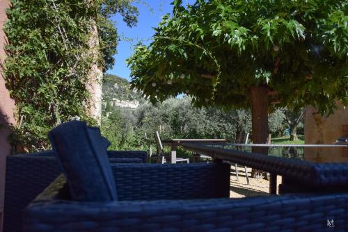 a group of chairs and a table with a tree at Le Mas Carré Séguret in Séguret