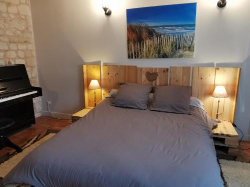 a bedroom with a bed and a piano at Petit havre de tranquillité in Loudun