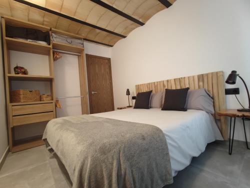 een slaapkamer met een groot wit bed met een houten hoofdeinde bij Can Triadú in Camprodon