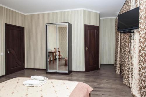 a bedroom with a bed with a mirror and a television at Chyhorinskyi Hotel in Kyiv