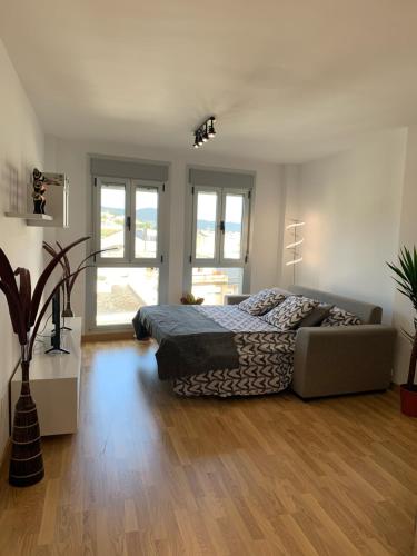 um quarto com uma cama e um sofá em Apartamento Porta da Vila em Viveiro