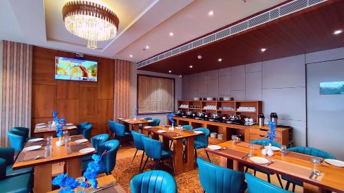 Un restaurante con mesas de madera y sillas azules. en Sshubh Hotel Nathdwara, en Nathdwara