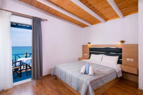a bedroom with a bed with a view of the ocean at Stelakis Beach in Limenaria