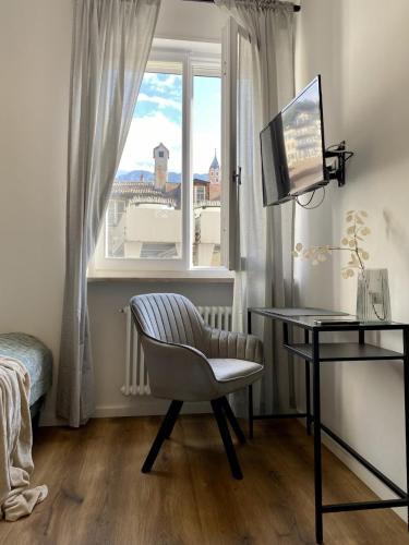 Schlafzimmer mit einem Schreibtisch, einem Stuhl und einem Fenster in der Unterkunft Galilei Apartment in Meran