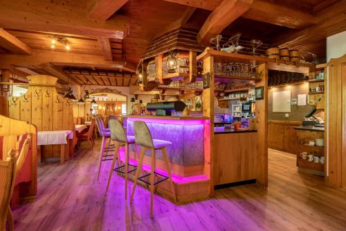 a bar in a restaurant with purple lighting at Hotel Ländenhof Superior in Mayrhofen