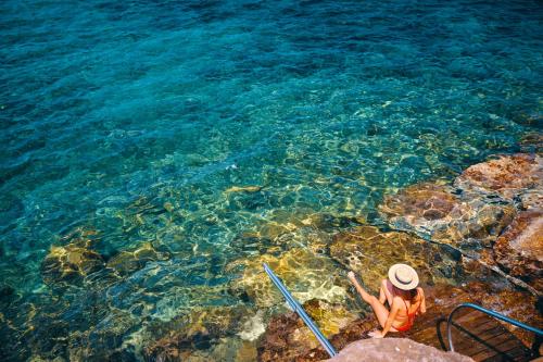 a person standing in the water near the ocean at Approdo Resort Thalasso Spa in Castellabate
