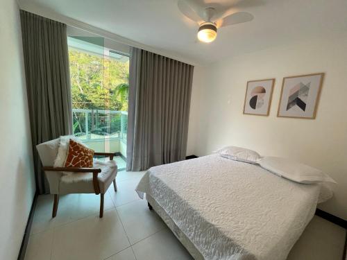 een slaapkamer met een bed, een stoel en een raam bij Apartamento em Santa Teresa in Santa Teresa