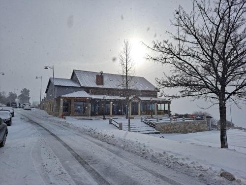 a building on a street covered in snow at Alojamento de montanha in Penhas da Saúde