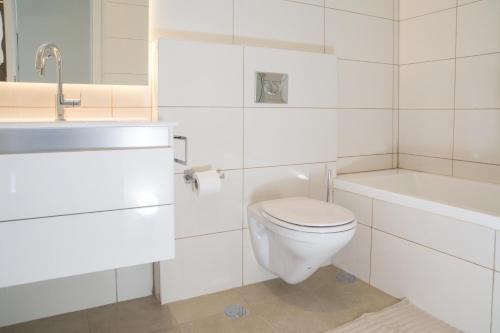a white bathroom with a toilet and a sink at Best location and family-friendly in Jerusalem