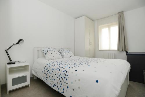 une chambre avec un lit blanc et une fenêtre dans l'établissement Heptagone_2, à Saint-Quentin