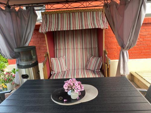 a table with a hat and flowers on it at Ferienwohnung Rosenweg in Schmalkalden
