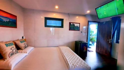a bedroom with a bed and a flat screen tv at Sena home 4th-Rooftop Overlooking Danang Dragon bridge in Da Nang