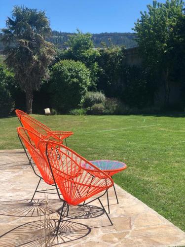 two orange chairs and a glass table on a patio at My Pod House in Esquel