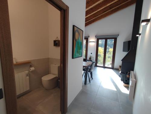 a bathroom with a toilet and a table at Can Triadú in Camprodon