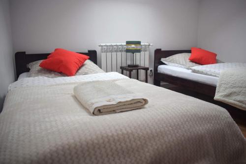 a bedroom with two beds with white and red pillows at Apartament Bieszczady in Hoczew