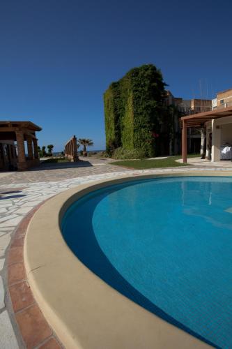 a large blue swimming pool in a yard at Bella Beach Hotel in Hersonissos