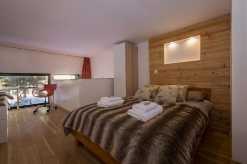 a bedroom with a bed with two towels on it at Résidence Grand Roc - Bruyères 022 - Happy Rentals in Chamonix