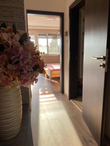 a hallway with a vase with flowers in it at Idevár-Lak Apartman in Velence