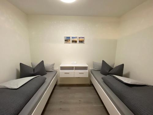 Duas camas num pequeno quarto com uma mesa em Ferienwohnung Rodachaue em Bad Rodach