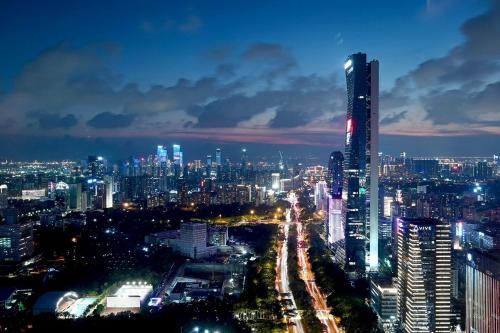 a city skyline at night with a tall skyscraper at Crowne Plaza Shenzhen Nanshan by IHG in Shenzhen