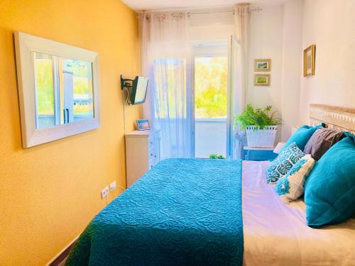 Un dormitorio con una cama azul y una ventana en Cozy apartment, en Ampuero