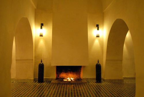 a room with a fireplace with two lights on the wall at Hotel & Spa Dar Bensouda in Fez
