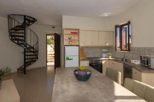 a kitchen with a spiral staircase in the middle at Armonia Seaside Villas in Vasilikos